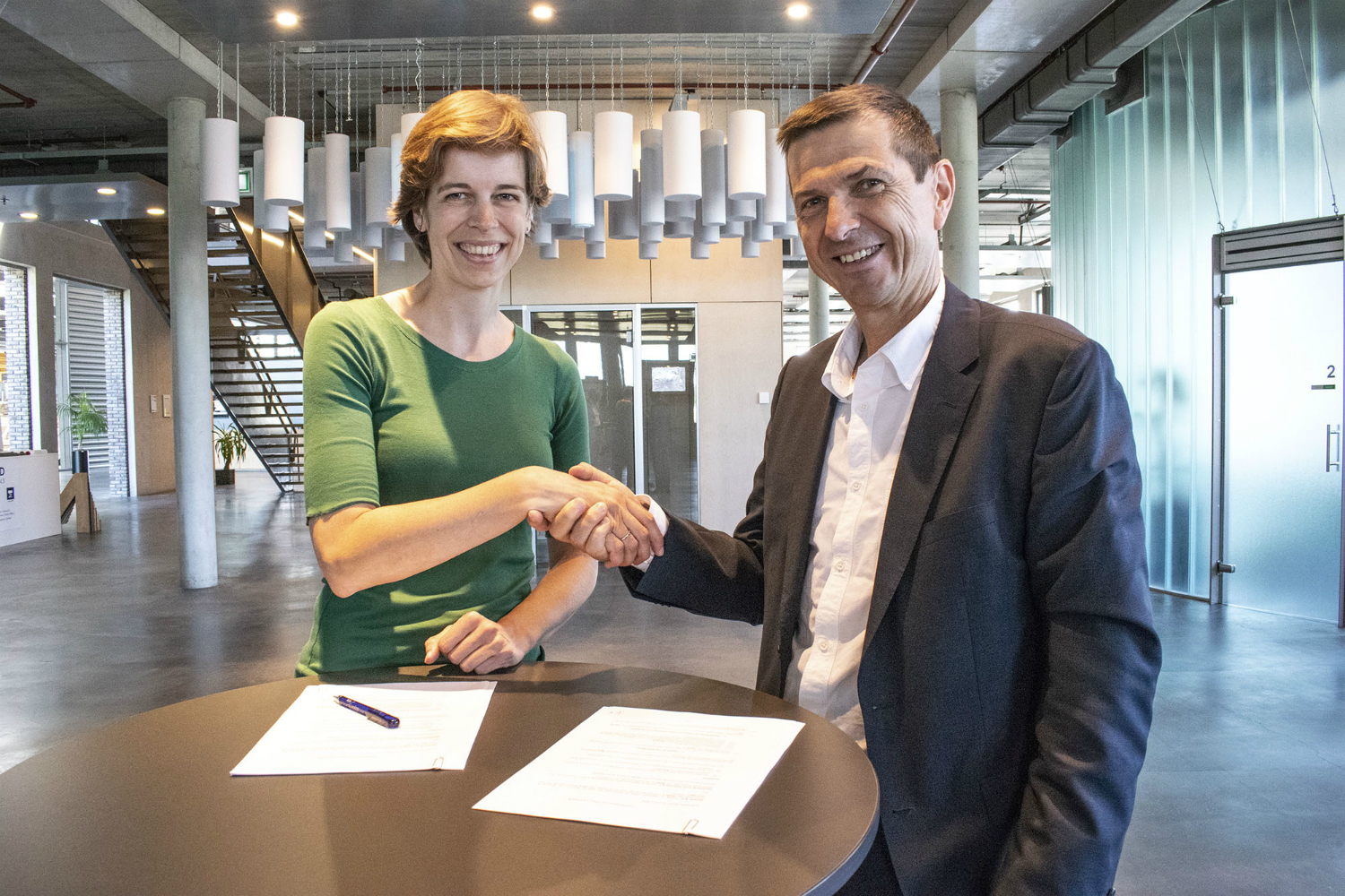 Adrienne Vertooren, CEO van Merford, en Eric Bertrand, Business Director Technical Foams bij Recticel, schudden elkaar de hand na het ondertekenen van de overeenkomst. Adrienne Vertooren, CEO van Merford, en Eric Bertrand, Business Director Technical Foams bij Recticel, schudden elkaar de hand na het ondertekenen van de overeenkomst.
