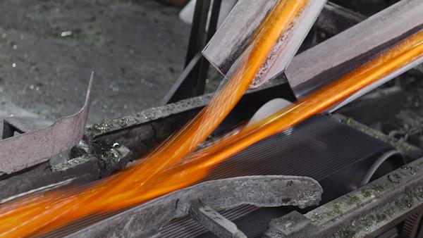 Het vloeibare glas verlaat de oven Het vloeibare glas verlaat de oven