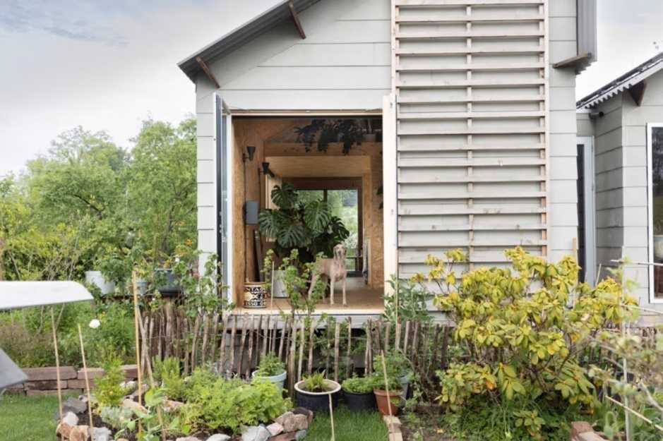 Houten woning met hond voor het raam