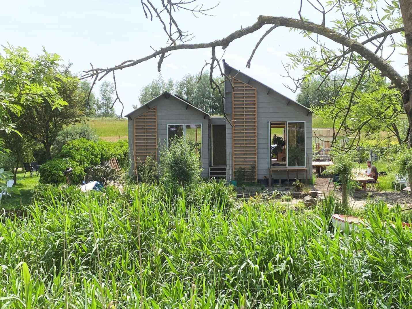 Prefab houten huis Man in tuin met houten huis