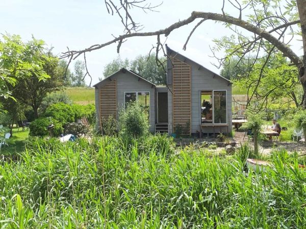 Man in tuin met houten huis