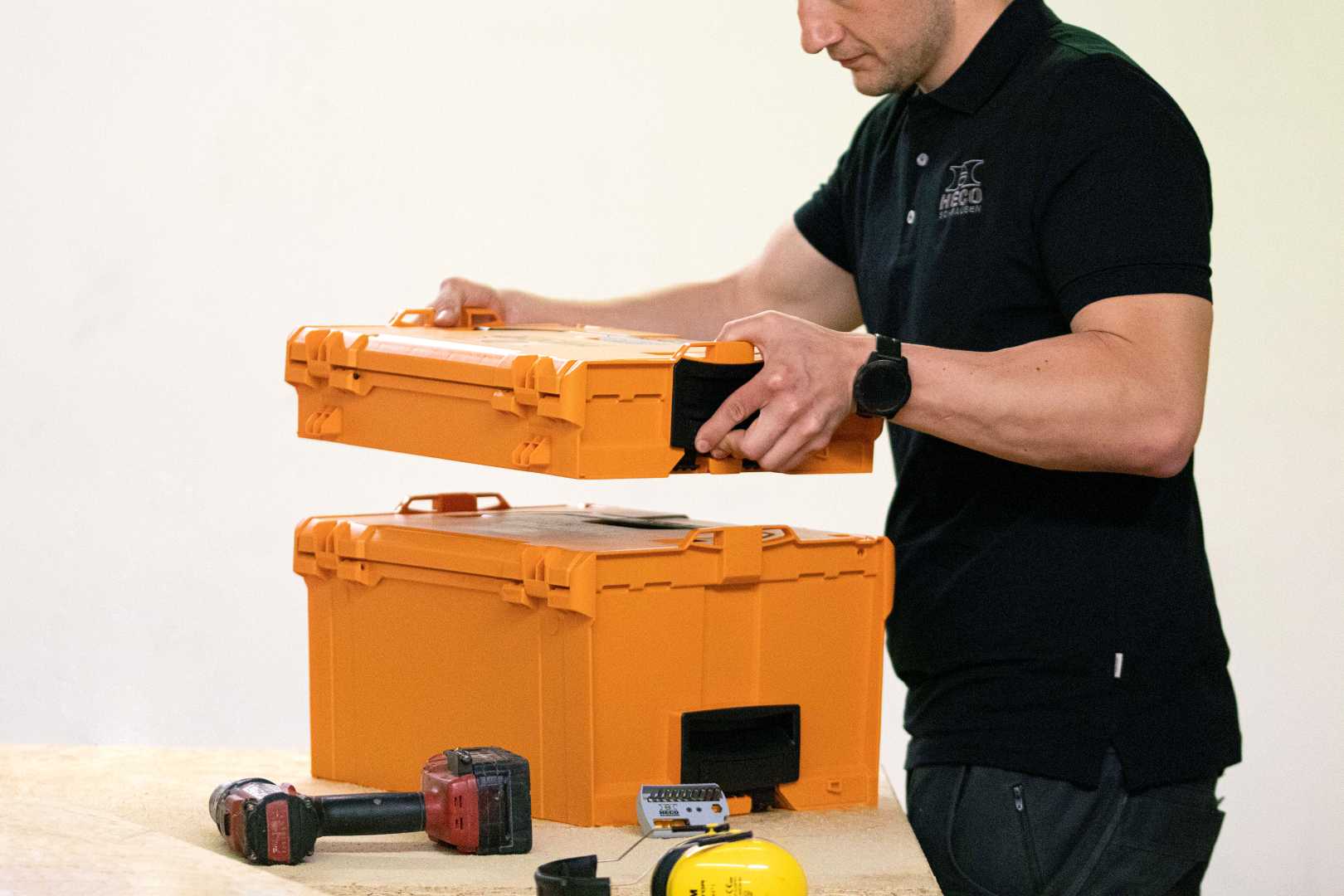 HECO systeemkoffer L-BOXX stapelbaar man plaatst systeemkoffer op andere