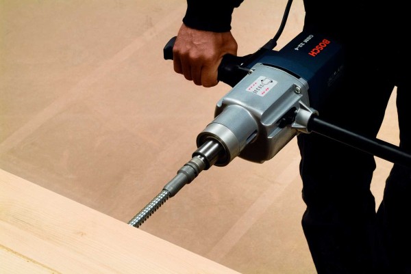 man boort draadstangen in hout