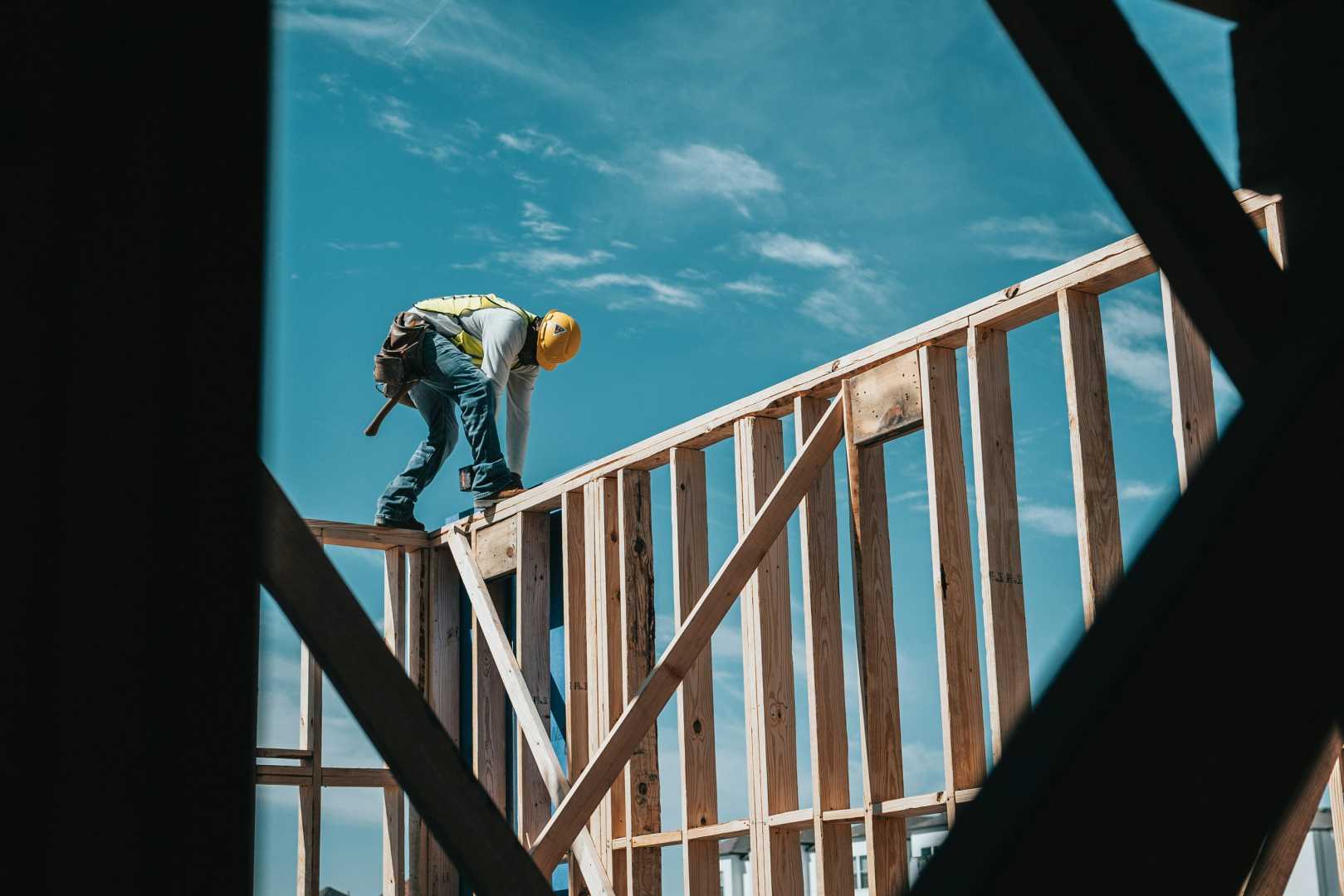 Aanbouw woning sneller realiseren met prefab oplossingen Bouwvakker op houten constructie