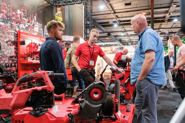 Beursbezoekers bij rode machines