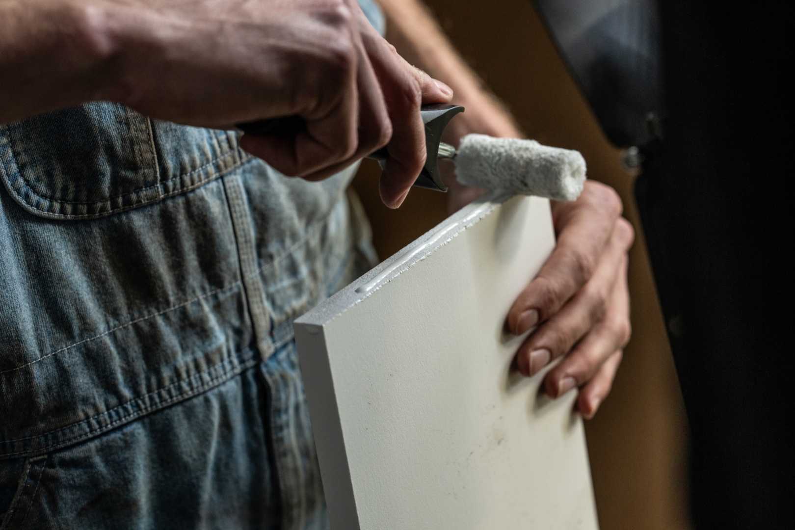 Unipanel verven Man verft een kunststofplank