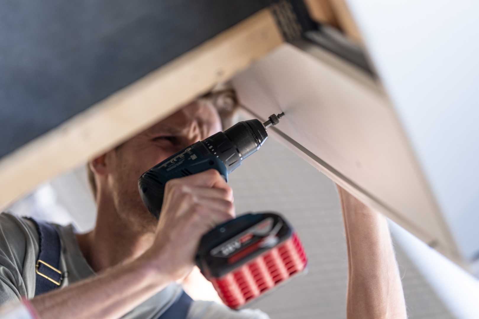 Unipanel schroeven Man schroeft een kunststofplank