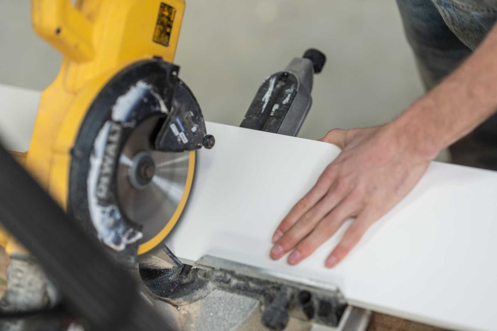 Unipanel zagen Man zaagt een kunststofplank