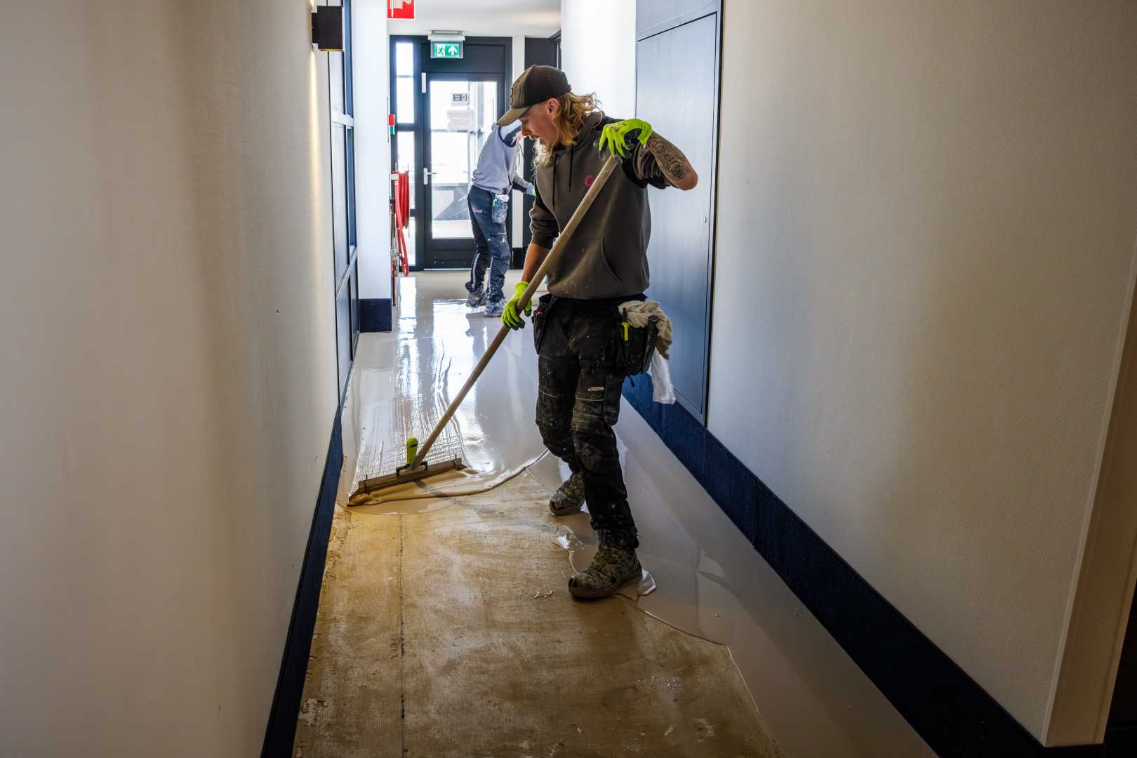 Verpompen van Eurocol 926 bij project COA in Amsterdam Werknemers brengen lijmlaag aan