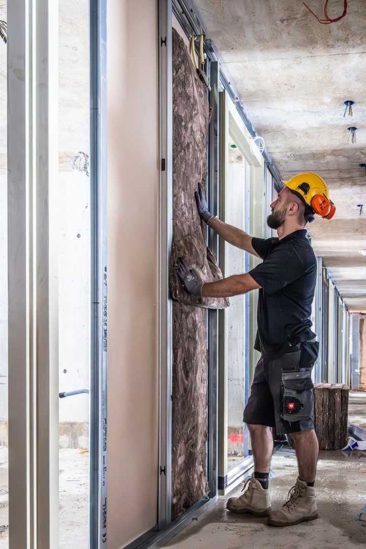 Acoustifit in scheidingswanden isolatiemateriaal wordt geplaatst
