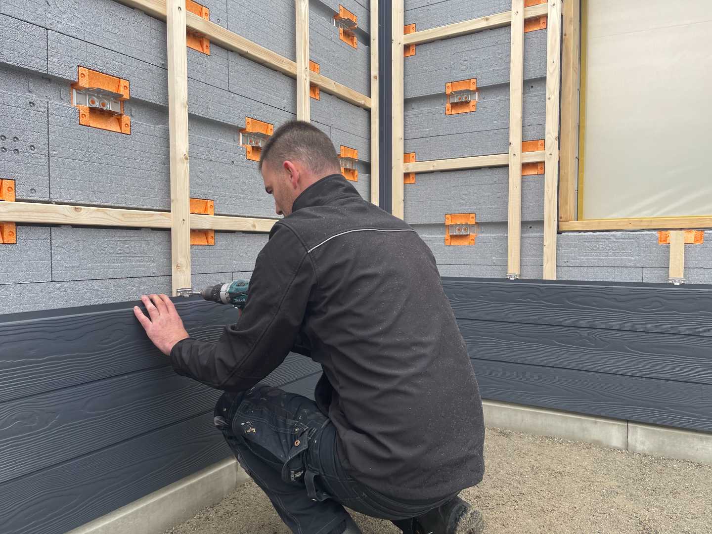 Planken worden op het stramien gemonteerd Planken worden op het stramien gemonteerd